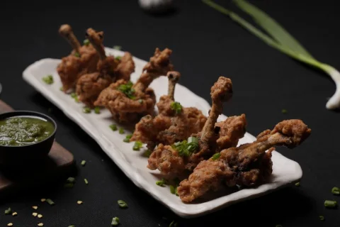 Chicken lollipops plated with green chutney, shot for a Hyderabad restaurant